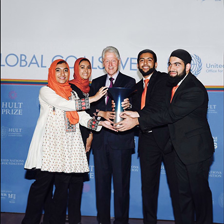 Gia Farooqi, Hasan Usmani, Moneeb Mian, and Hanaa Lakhani pose with trophy and President Bill Clinton