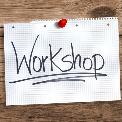 This image features the word "Workshop" handwritten on a piece of grid paper pinned to a wooden surface.
